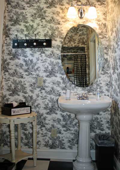 Bathroom with pedestal sink and oval mirror