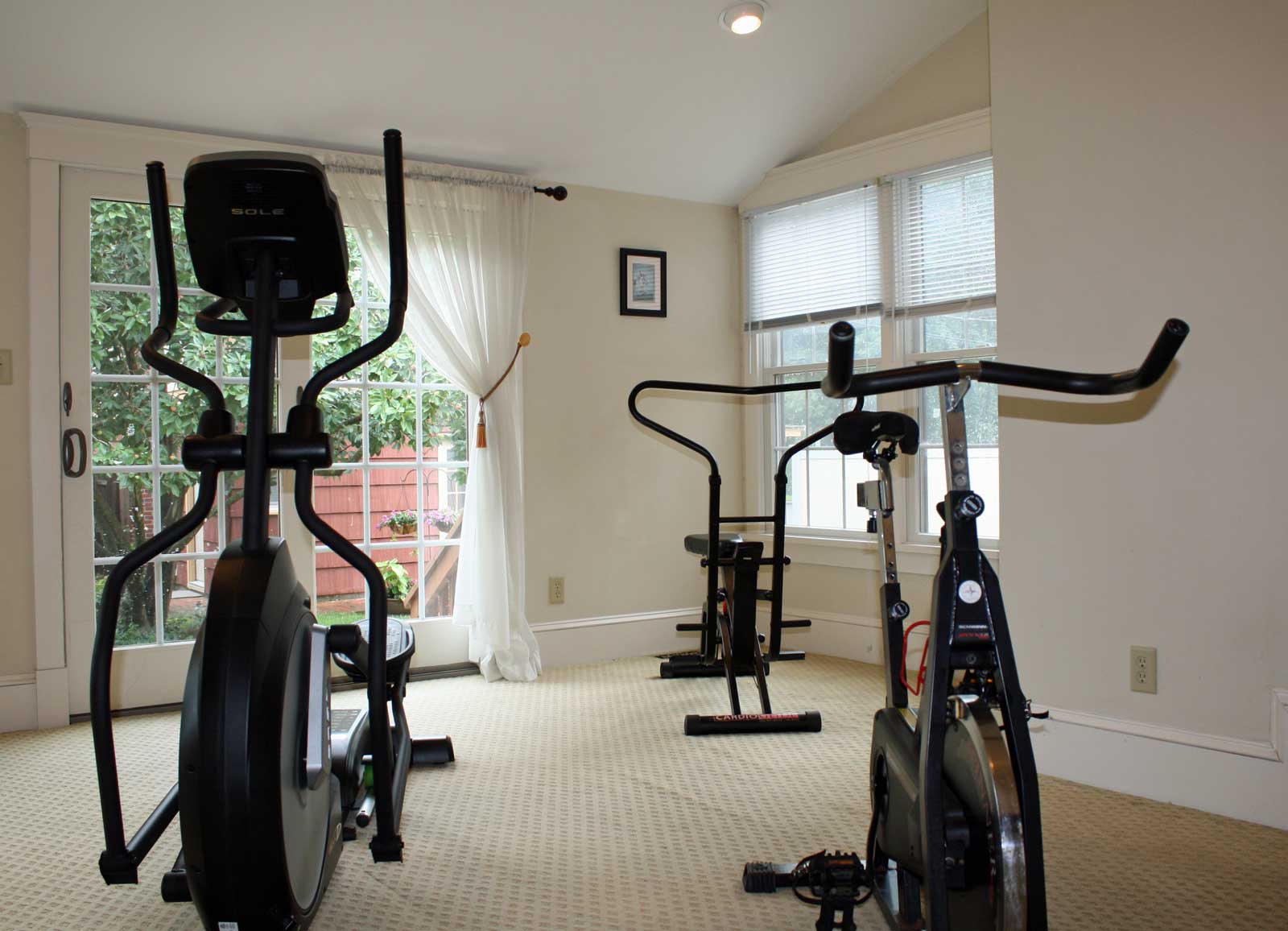Fitness room with spinner bike, elliptical machine, and rowing machine